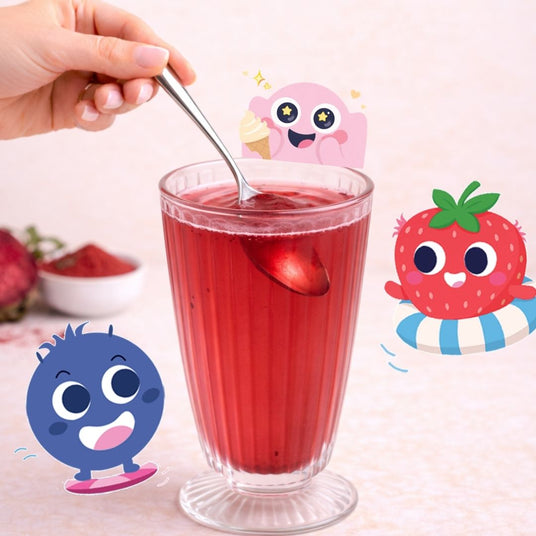 Glass of red juice with a spoon, surrounded by cartoon characters on a light pink background