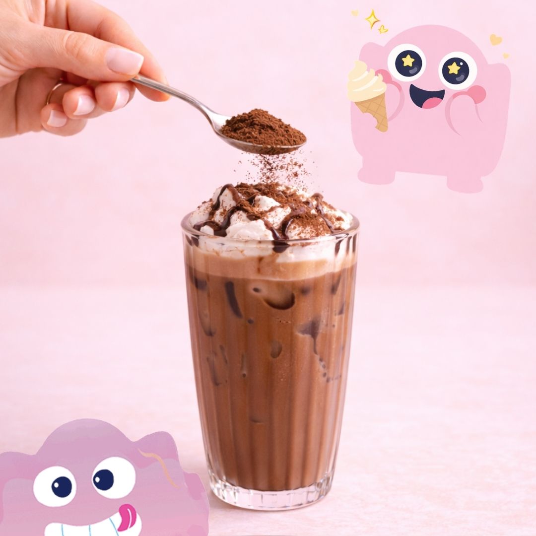 Chocolate drink with whipped cream and a spoonful of chocolate powder, pink background with cartoon characters.